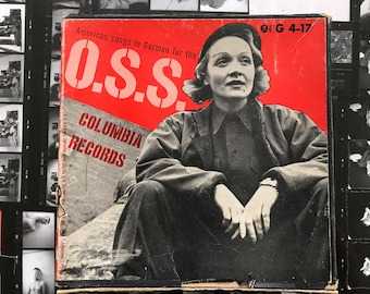 OSS wartime poster in red and black and white, highlighting a sitting woman in fatigues.