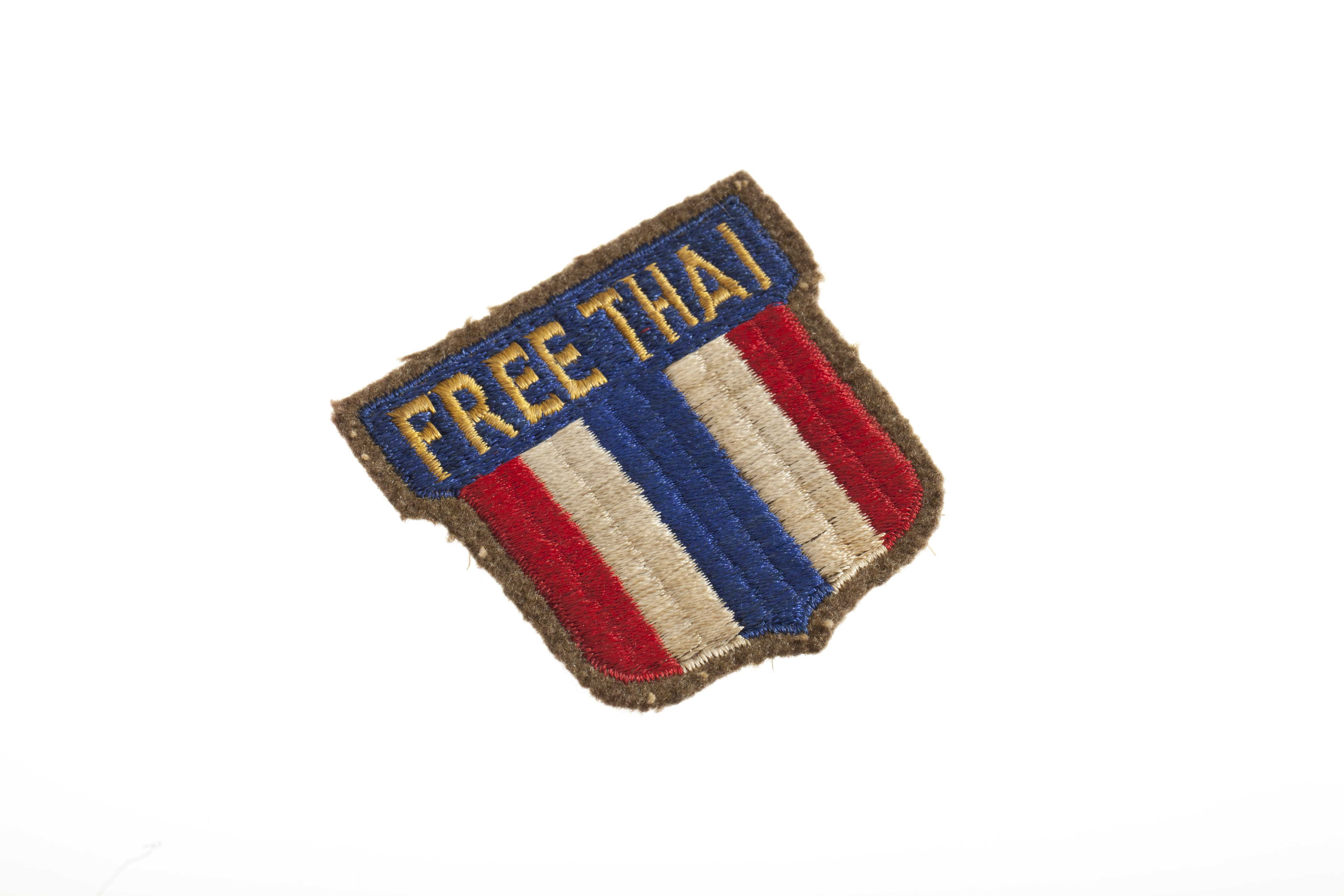 A small red, white, and blue patch with the words "Free Thai."