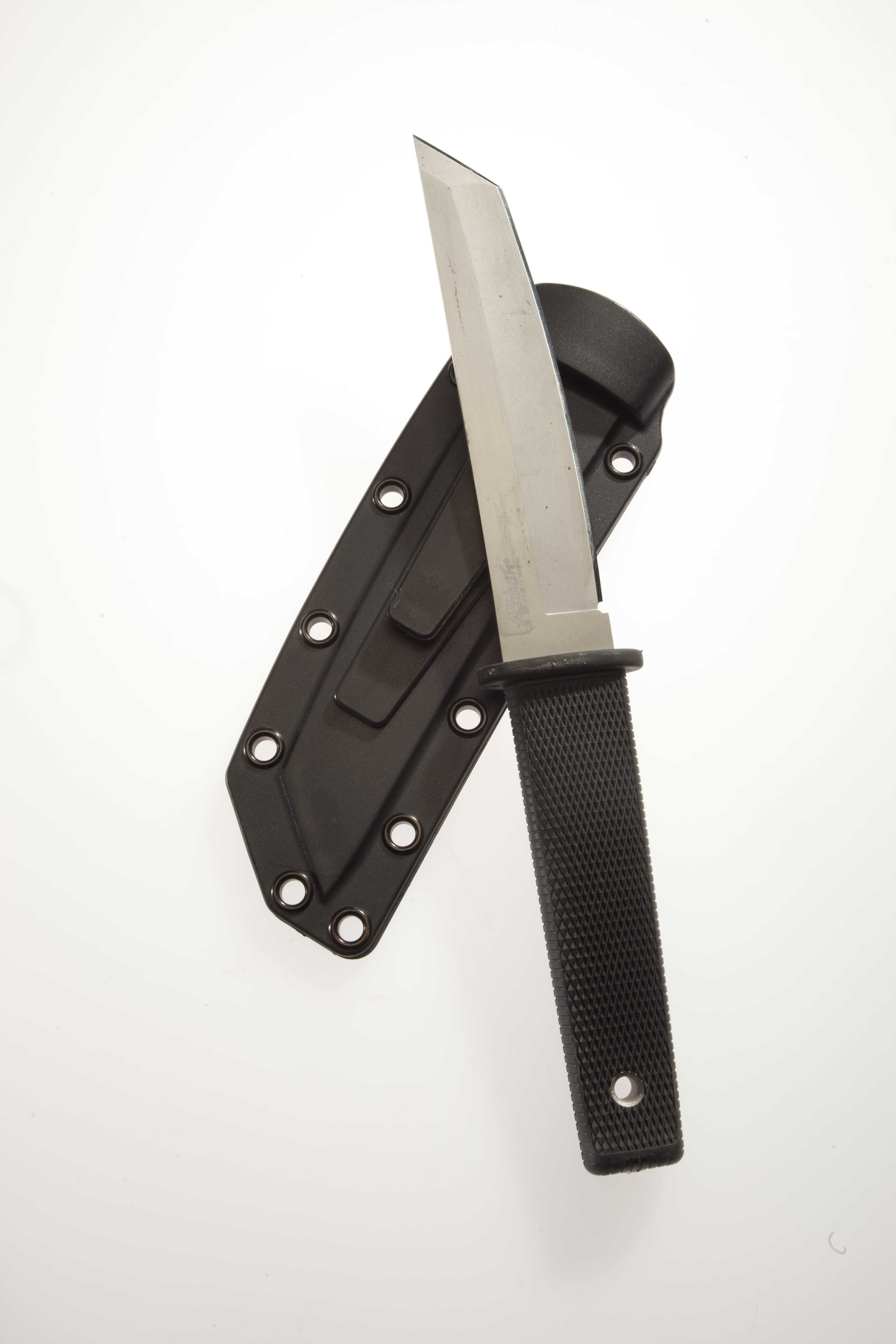 A knife with a black handle resting on top of a matching blade cover