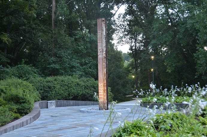 A rust-colored steel column, lit in the center of a walkway at CIA headquarters.