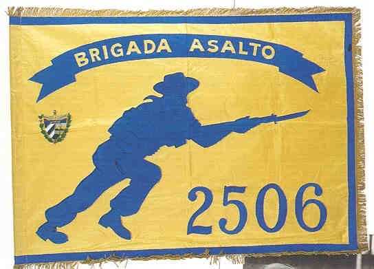 A yellow flag with a blue design of a man charging with a knife and the words, "Brigada Asalto 2506."