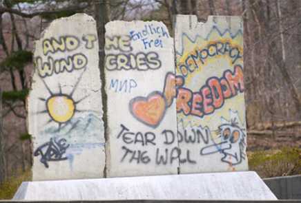 A close up of three, graffiti-covered concrete segments from the Berlin Wall.