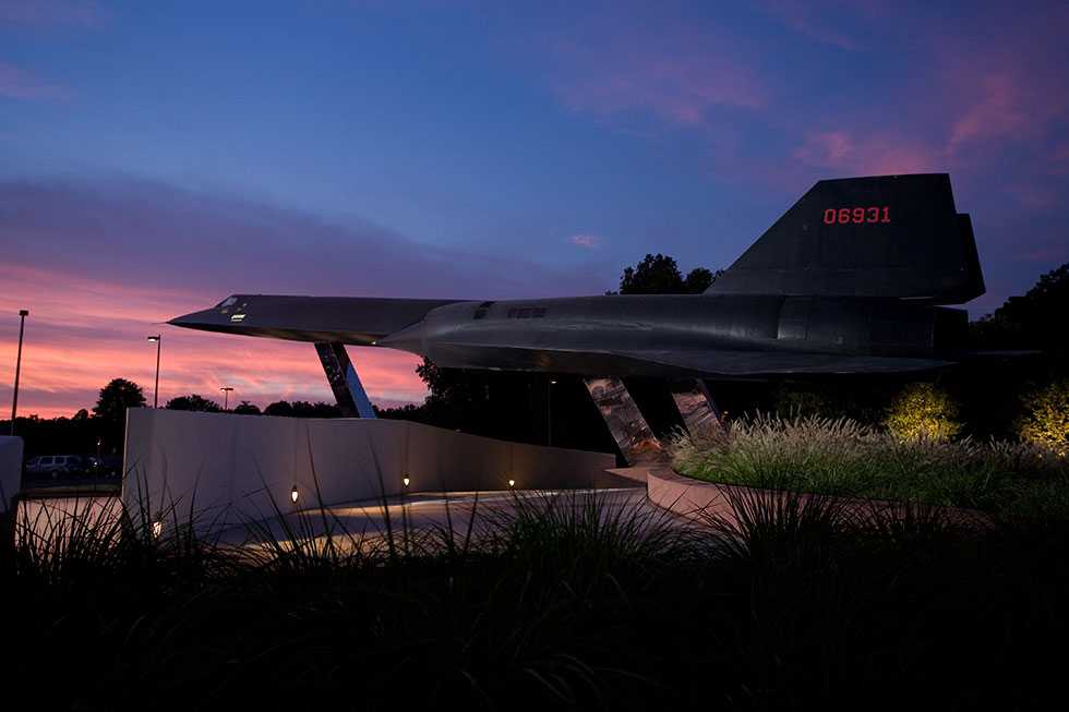 A side view of the black A-12 Oxcart on display at CIA Headquarters at sunset, with the red numbers 06931 on the tail.