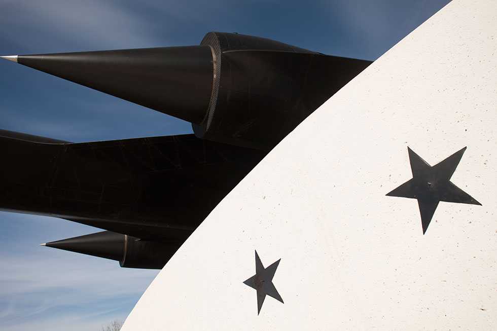 A view of the black A-12 oxcart from below, which has a white barrier with black stars underneath it.