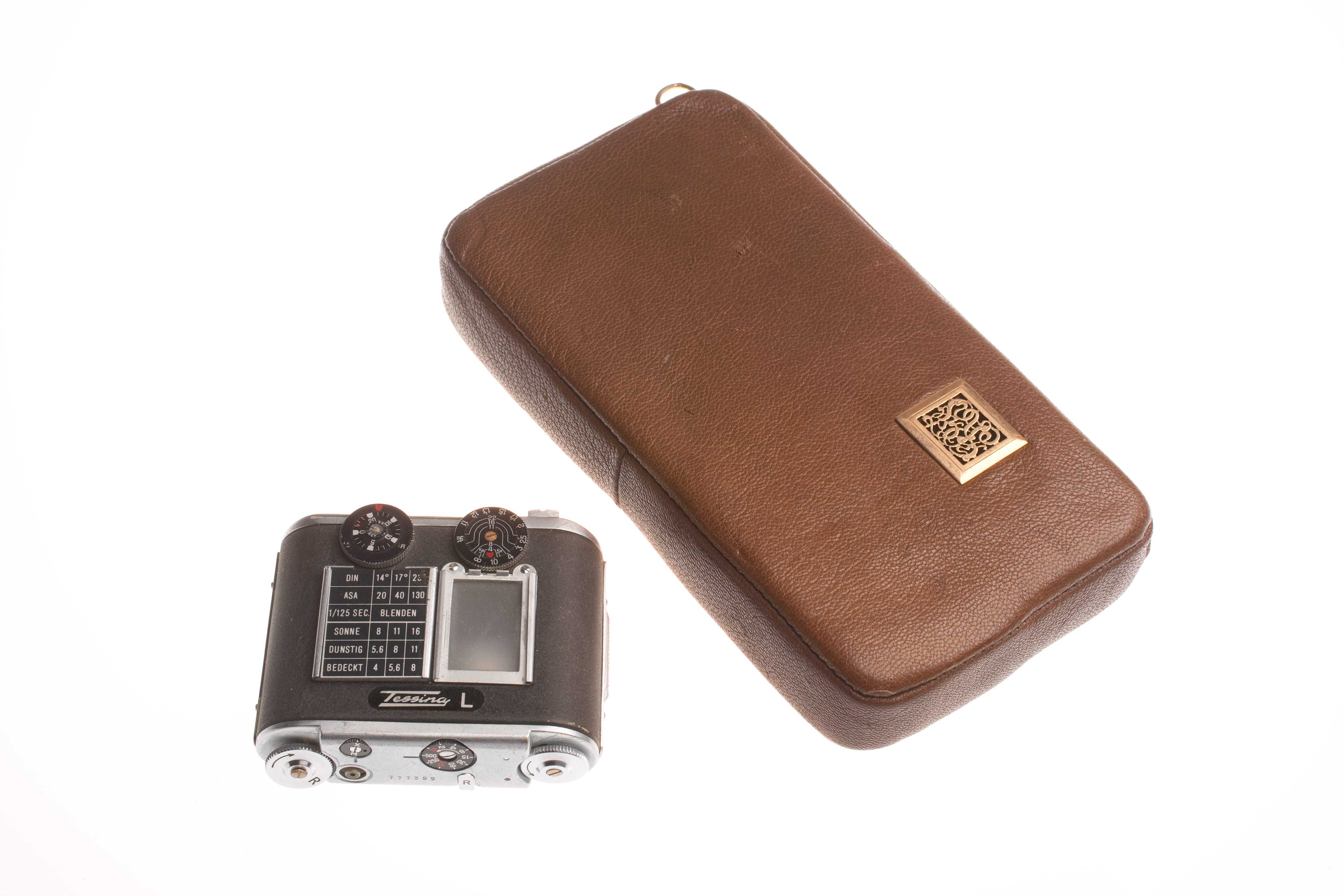 A small black 35-mm film camera and a brown modified tobacco pouch