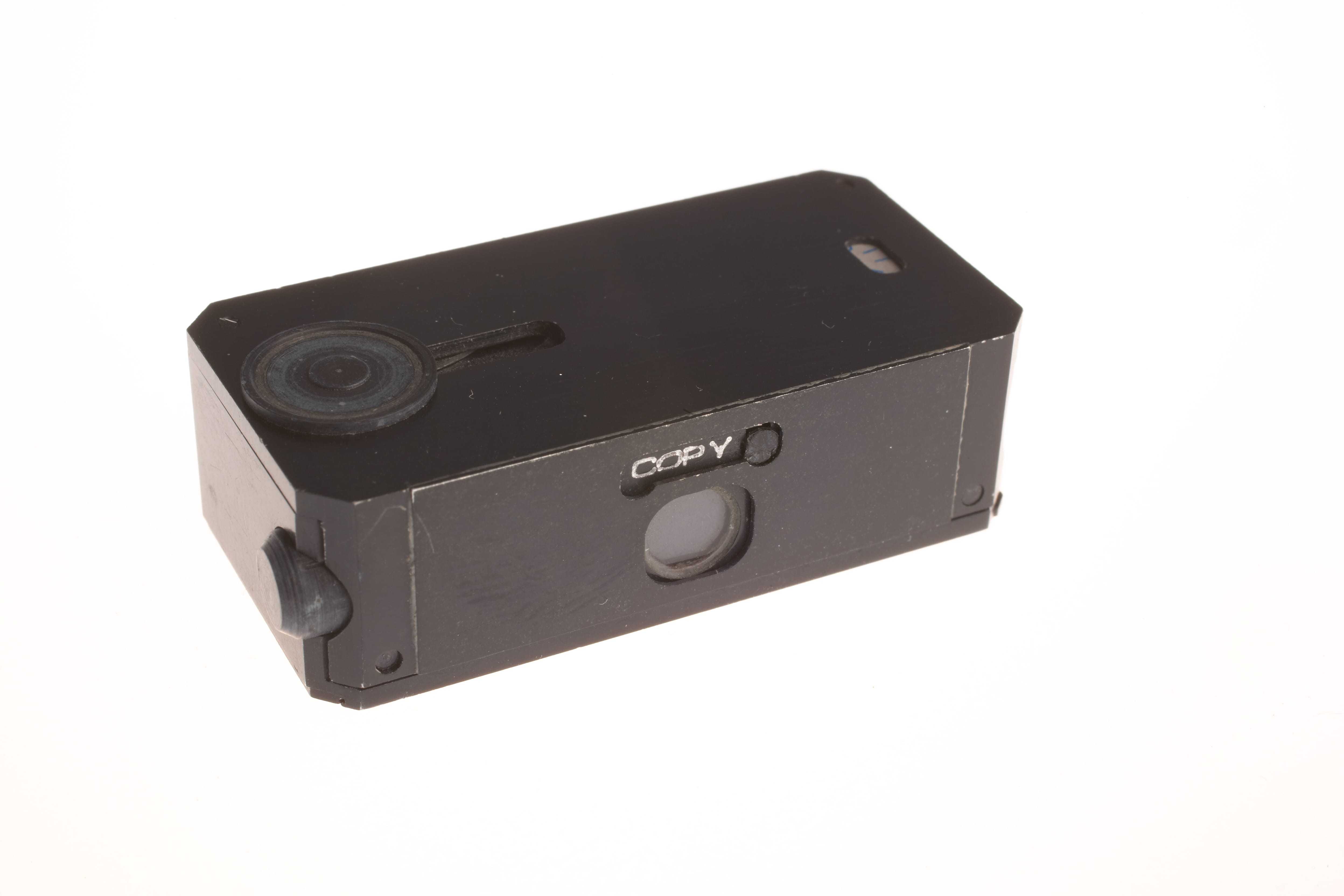 A small metal box with a small opening for a camera lens