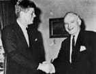 A black and white photograph of JFK shaking hands with William Donovan.