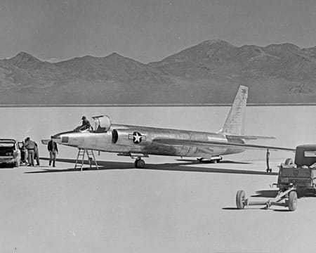 Black and white photo of a U-2 spy plane on ground with mountains in the background.