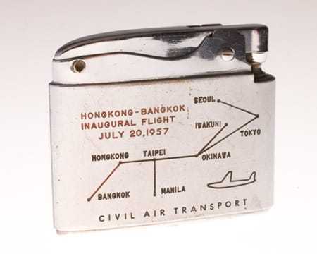 The reverse side of the lighter displays the path of the Hong Kong-to-Bangkok inaugural flight that took place on July 20, 1957