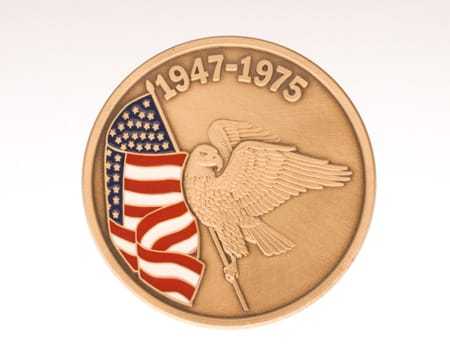 ", The reverse side of the coin, depicting an Eagle carrying an American flag below the dates 1947-1975