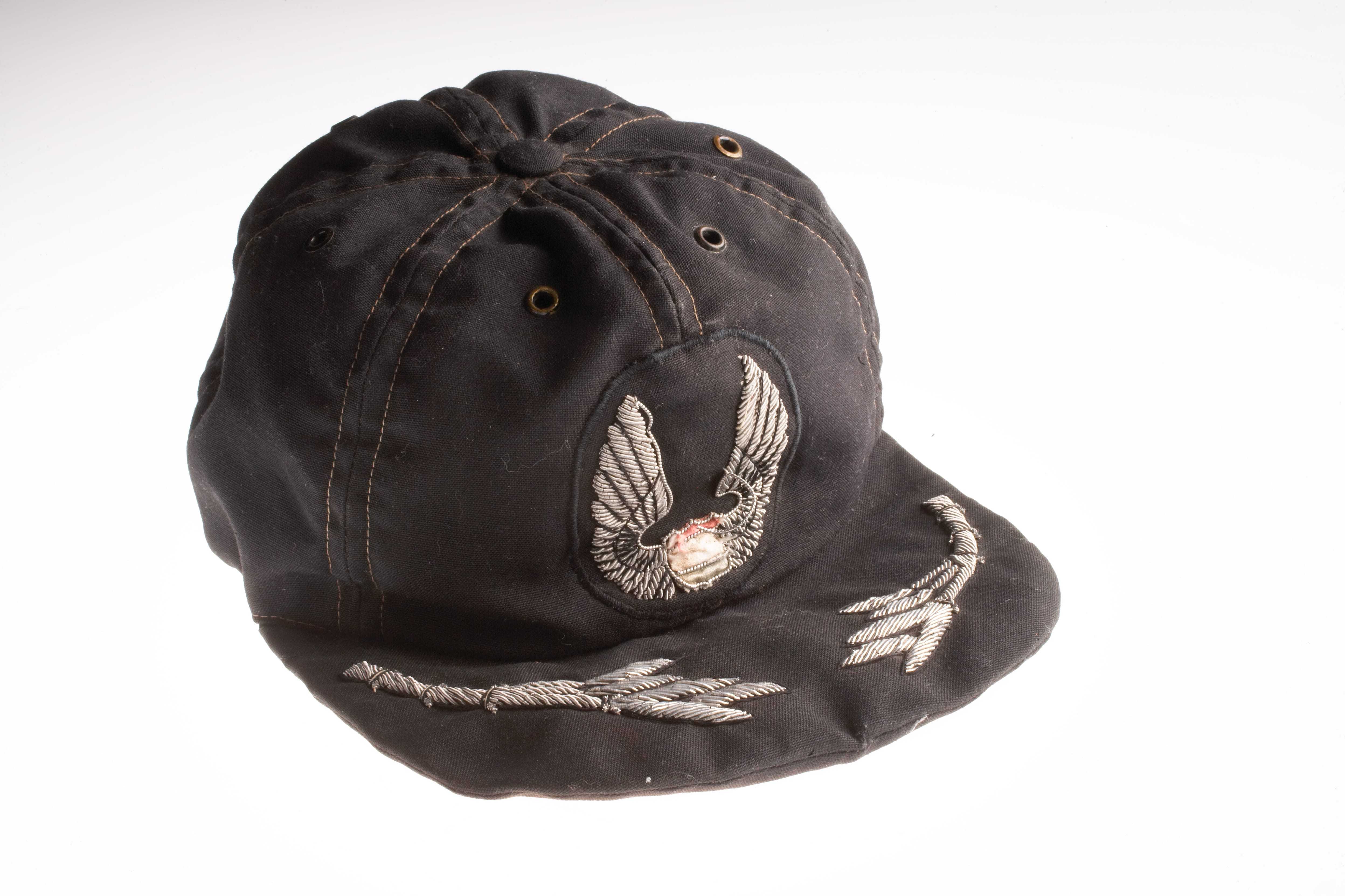 A worn black baseball cap with the Air America insignia embroidered on it