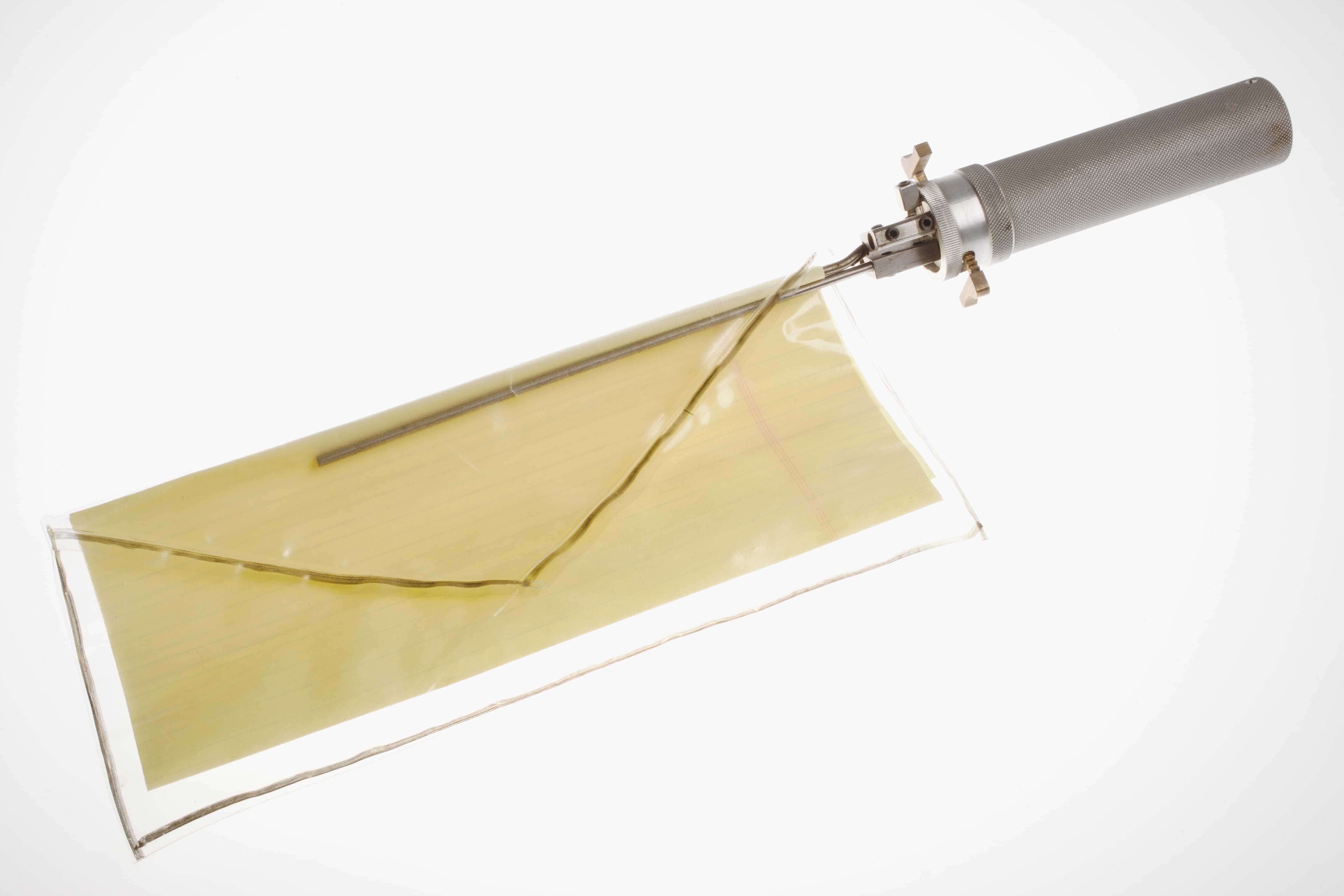 Long, thin pincers on a handle, showing how the device would work with a transparent envelope