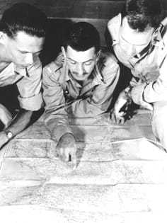 Three CIA field officers study a map.
