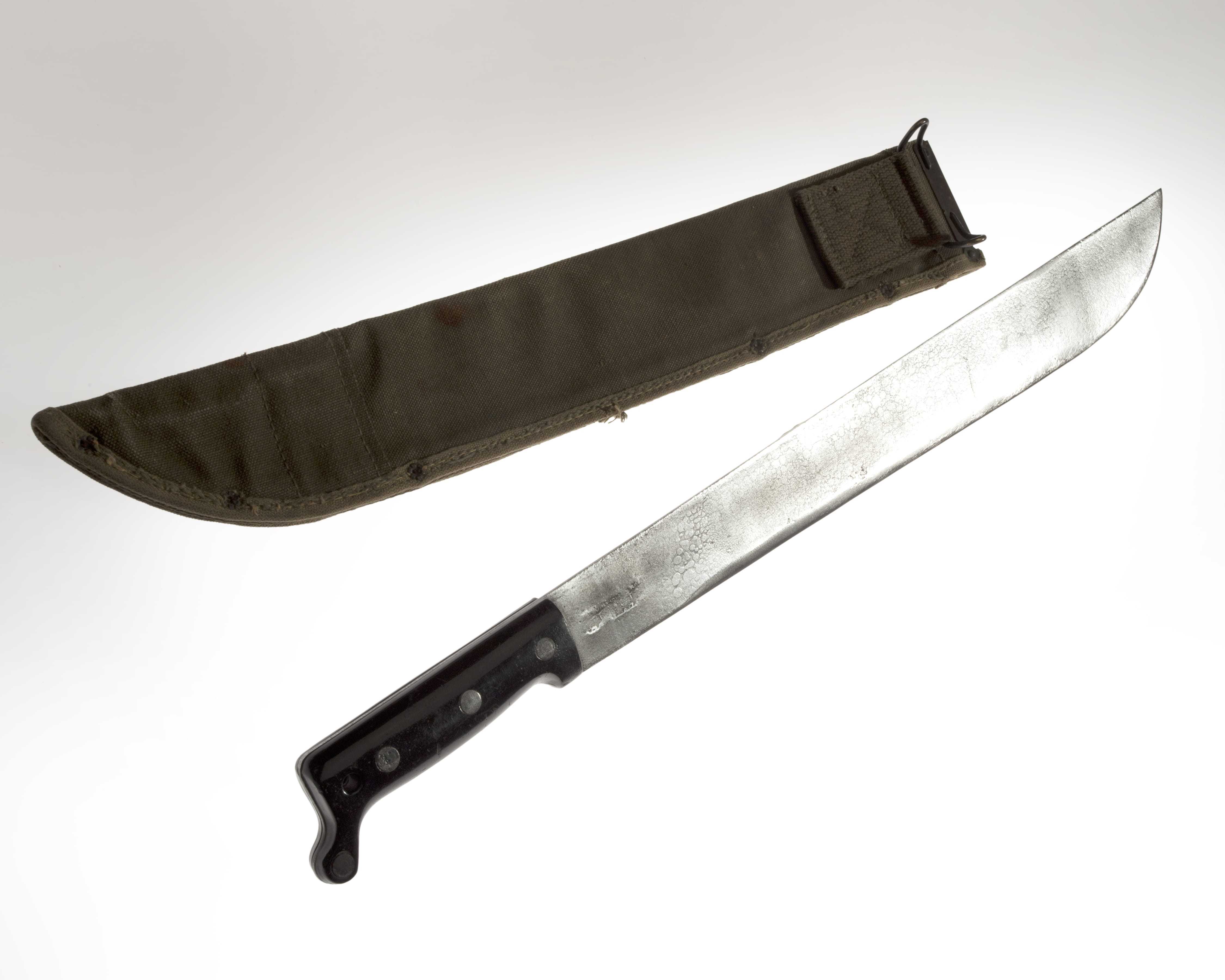 A machete with a black handle and a dark cloth sheath