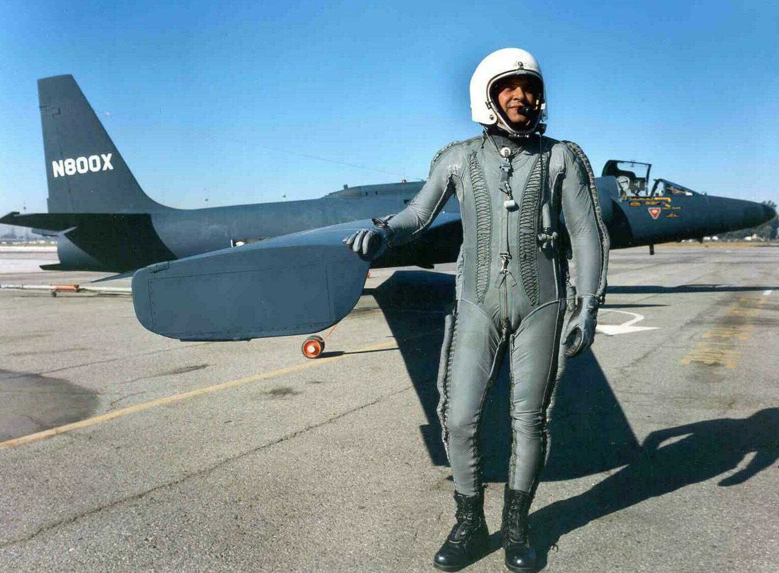 man in flight suit standing in front of a u2 plane
