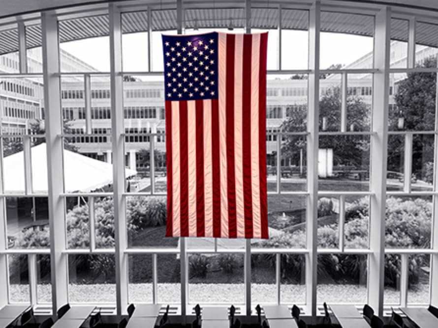 U.S. flag hanging in front of large windows in the CIA headquarters