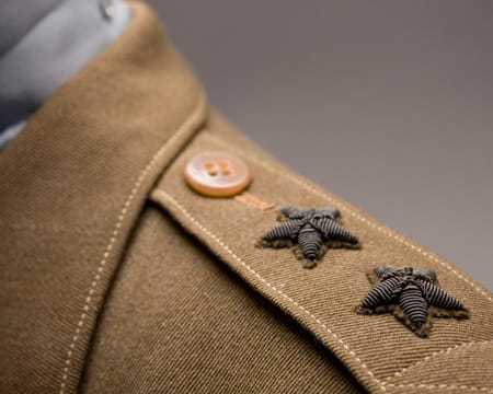 A close up of the left shoulder of the jacket which has two black stars sewn onto it