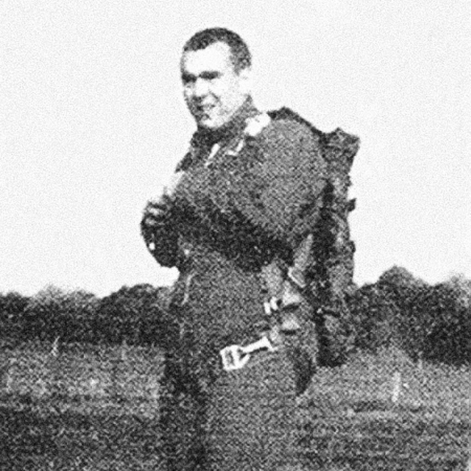 A faded black and white photograph of Michael A. Maloney standing in a field.