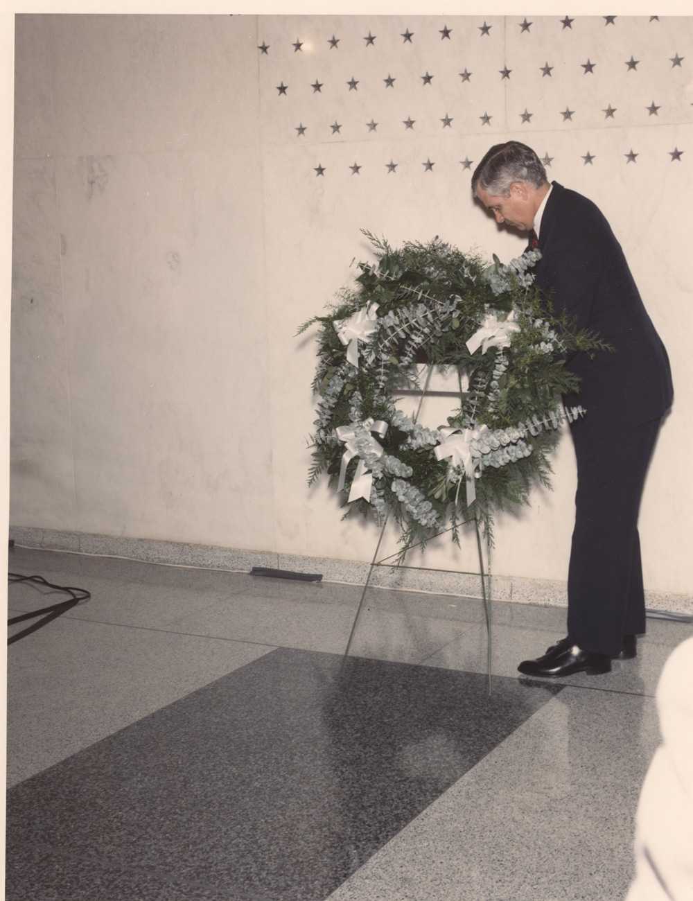 DD/CIA gates laying a wreath on an easel in front of the memorial wall.