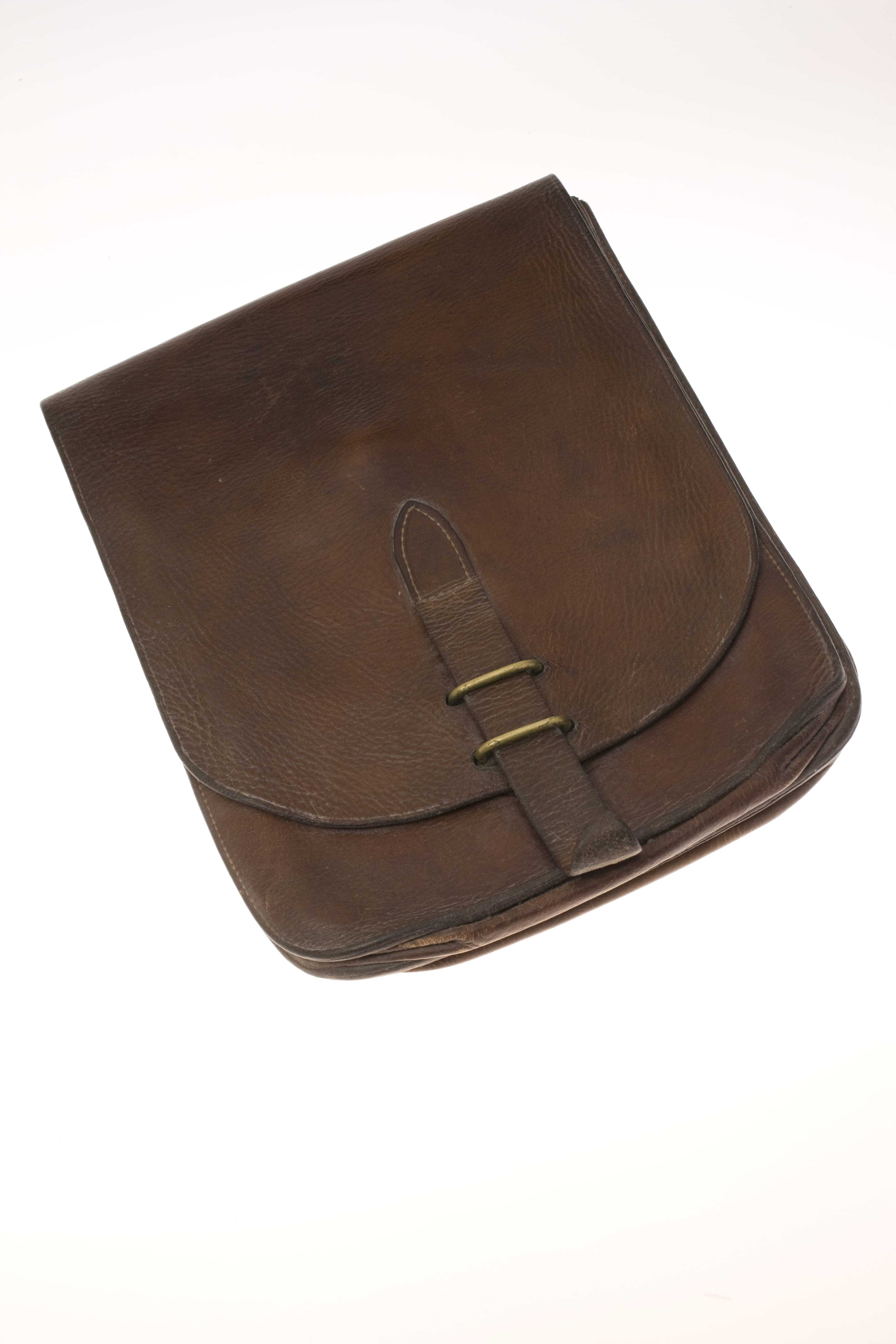 A brown leather saddle bag with a gold clasp