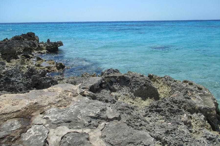 A rocky shore against a turquoise sea at Bay of Pigs, Cuba.