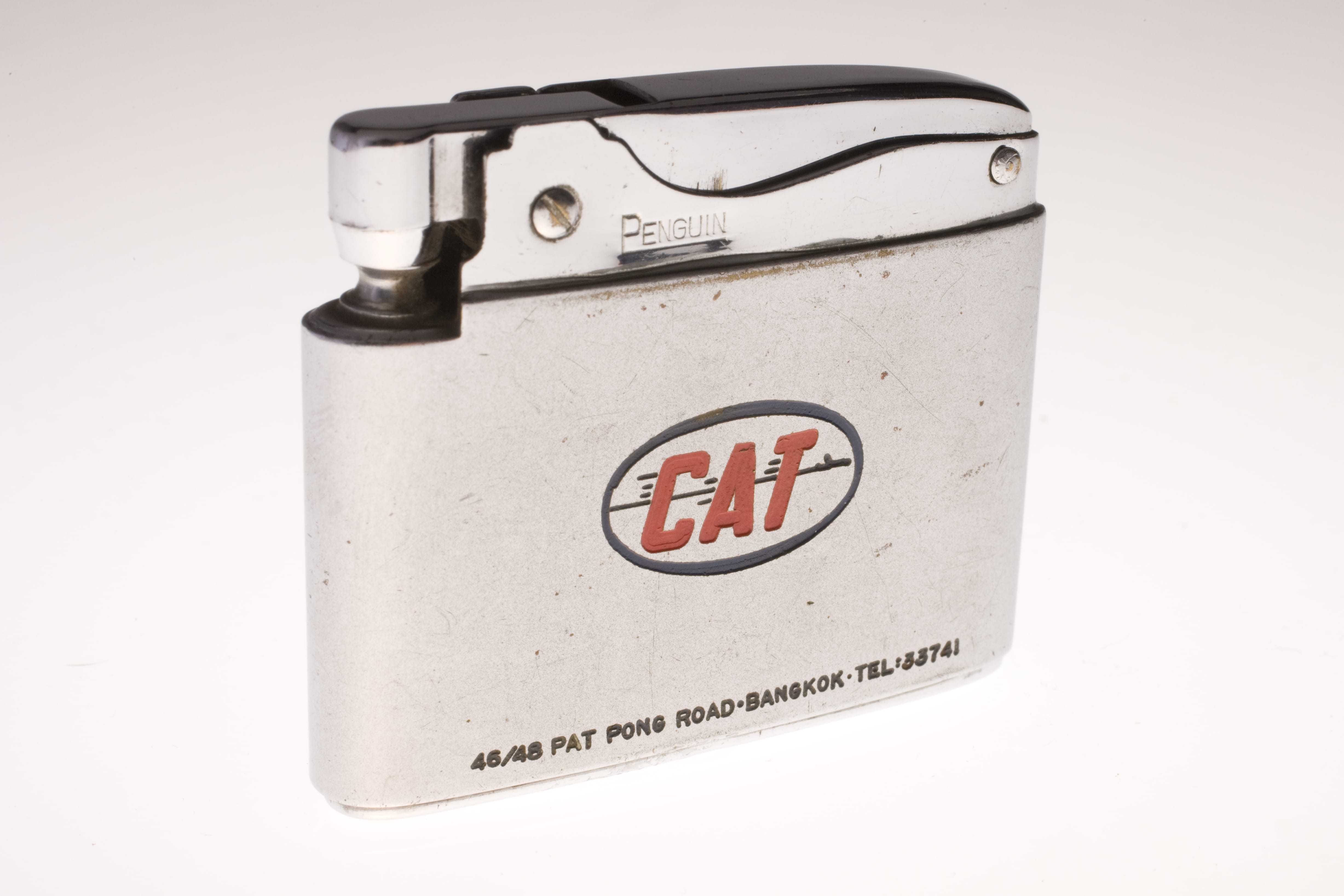 A white cigarette lighter with the Civil Air Transport logo engraved on the front