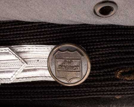 A metal button on the side of the cap, also displaying the Air America logo