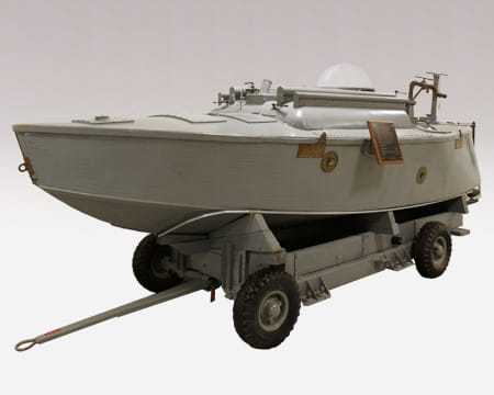 An enclosed boat on a four-wheeled frame