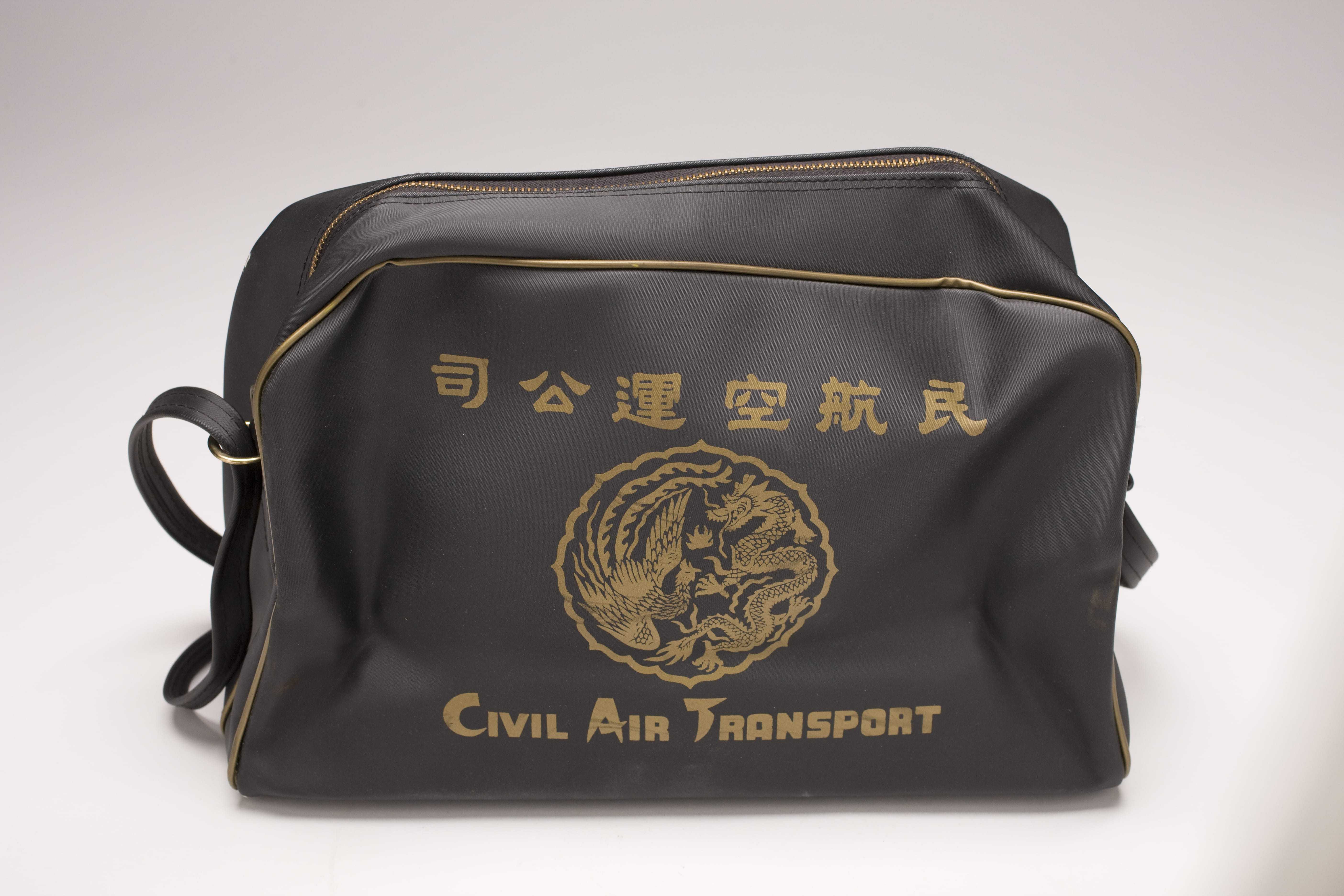 A black zippered bag with the CAT logo printed in gold on the side