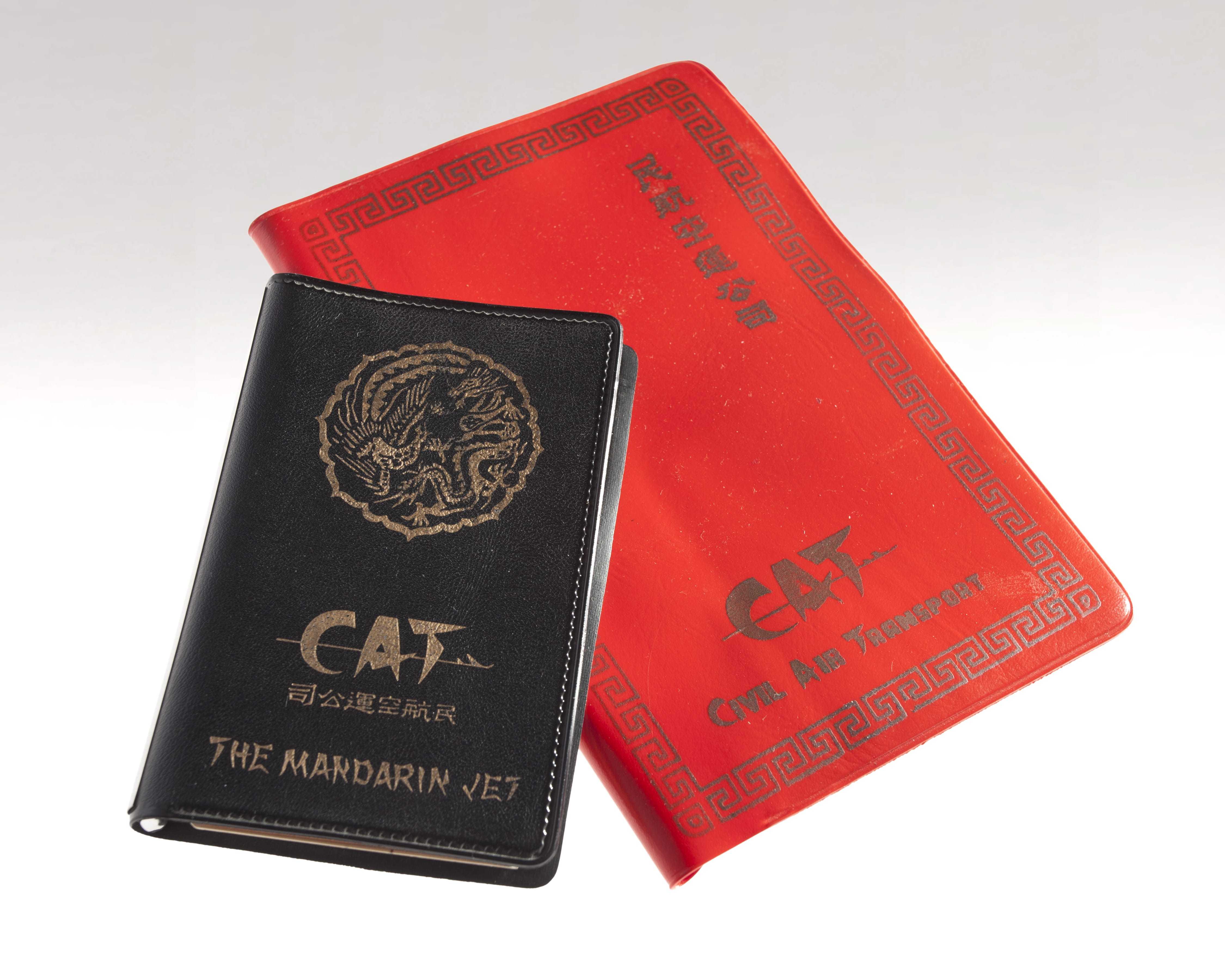 Two CAT notebooks, one black and one red, both with the CAT logo