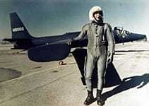 image of a man standing in front of an airplane.