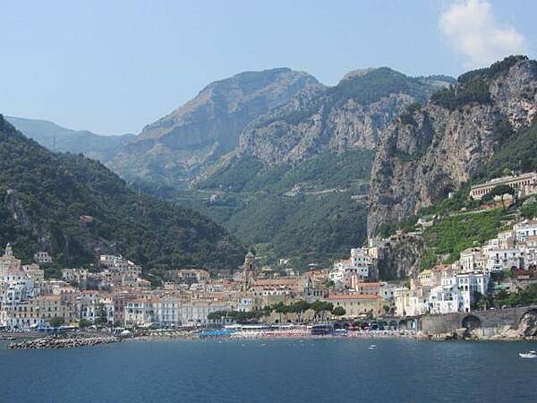 View of the city of Amalfi with Mount Cerreto (1,315 m; 4,314 ft) in the background. Amalfi was a maritime power with 70,000 residents until 1343 when an earthquake and subsequent tsunami caused most of the city and population to fall into the sea and destroyed the port. The tower of the Amalfi Cathedral (Duomo di Amalfi), built in 1208 and named Saint Andrew&apos;s Cathedral, may be seen in the foreground.