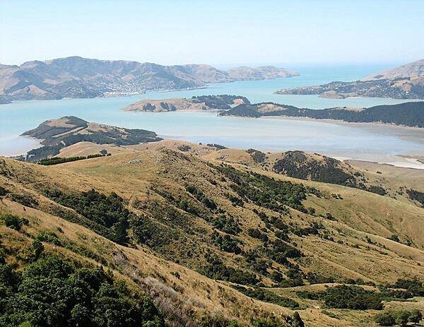 This photo was taken looking southeast on the Banks Peninsula on South Island. The peninsula was formed from eroded remnants of two large composite shield volcanoes, the dominate craters forming the Lyttelton and Akoroa Harbors. The mountainous nature of the peninsula is atypical within the surrounding region.