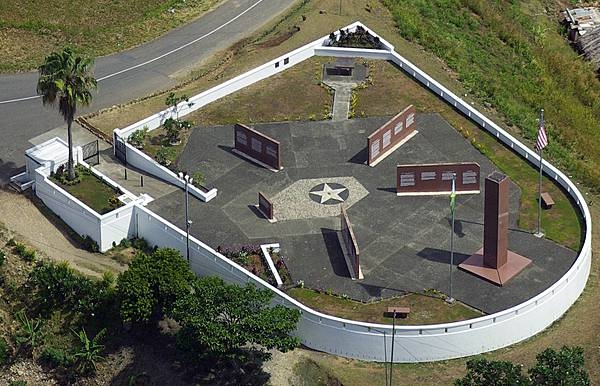 The World War II Guadalcanal American Memorial on Skyline Drive on Guadalcanal overlooks the town of Honiara and the Pacific Ocean. The site, located on the first hill occupied by US forces, honors those Americans and Allies who lost their lives during the Guadalcanal Campaign of World War II (7 August 1942 to 9 February 1943). The memorial consists of a 4-foot square, 24-foot tall pylon on which is inscribed: “This memorial has been erected by the United States of America in humble tribute to its sons and its allies who paid the ultimate sacrifice for the liberation of the Solomon Islands 1942-1943.” The four directional walls point to the four major battle areas. Inscribed on these walls are descriptions of the battles and a listing of the US and Allied ships that were lost. The monument was dedicated on 7 August 1992, the 50th anniversary of the American landing on Guadalcanal. Photo courtesy of the American Battle Monuments Commission.