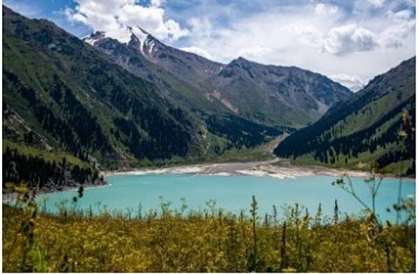 Big Almaty Lake is a natural alpine reservoir located in the Trans-Ili Alatau Mountains, 15 km south of Almaty in Kazakhstan. The lake is 1.6 km in length, up to 1 km in width, and between 30-40 m deep. The lake flows into the Big Almaty River and is part of the Ile-Alatau National Park. Depending on the time of the year, the color of the lake changes from light green to turquoise blue. The lake is the main water source for the residents of Almaty.