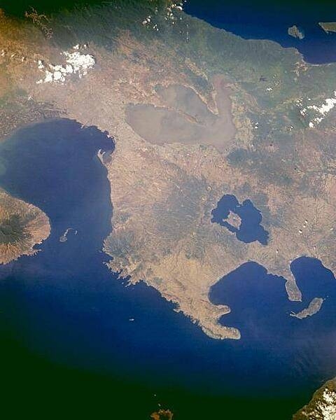 Trilobed Laguna de Bay, the largest lake in the Philippines, is visible near the upper center of this east-looking, photograph of central Luzon, Philippines. The lake is more than 51 km (32 mi) long and covers 891 sq km (344 sq mi). Its outlet, the Pasig River, exits at the northwest corner of the lake, flows westward through Manila, and empties into Manila Bay. South of Laguna de Bay are the dark blue waters of Taal Lake, a filled caldera that surrounds Volcano Island. The island is home to Taal Volcano (300 m; 984 ft high) with a crater more than 2 km (1 mi) wide. The island of Corregidor, which served as the focal point in the defense of the city of Manila during World War II, is the tiny tadpole-shaped island at the entrance to Manila Bay in the center left. Photo courtesy of NASA.