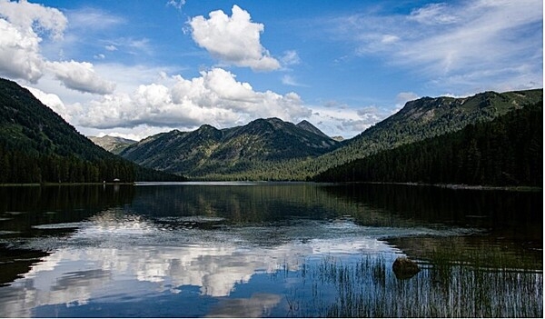 Lake Rakhmanov lies in the Altai Mountains of Eastern Kazakhstan. The lake's temperature is always low due to its depth, location, and its ice-cold tributaries. The lake is nearby Rakhman Springs in Katon-Karagay National Park. The springs are fed by warm thermal waters containing radon and nitrogen, optimal for wellness visits at a nearby sanatorium.