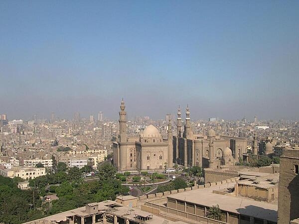 The Sultan Hassan and Ar-Rifai Mosques as seen from the Citadel with Cairo, Egypt, in the background. The Sultan Hassan Mosque and Madrasah (religious school) is a masterpiece of Mamluk architecture that was begun in 1356 and completed in 1363. It contains the burial chamber of the Sultan's two sons and is featured on the Egyptian hundred-pound note. The Ar-Rifai Mosque was built between 1869 and 1912. It houses the tomb of King Farouk, Egypt's last reigning monarch, and other members of the Egyptian royal family, as well as the tomb of the last shah of Iran.