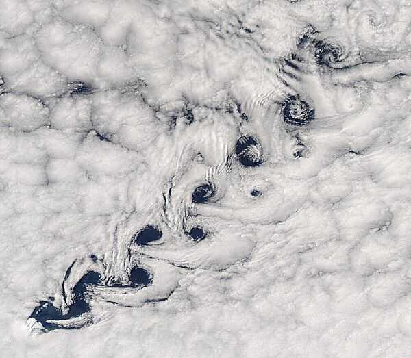 This image shows vortex-shedding occurring as winds pass Heard Island (in the lower left) resulting in a Kármán vortex street -- a repeating pattern of swirling vortices -- in the clouds. Photo courtesy of NASA.