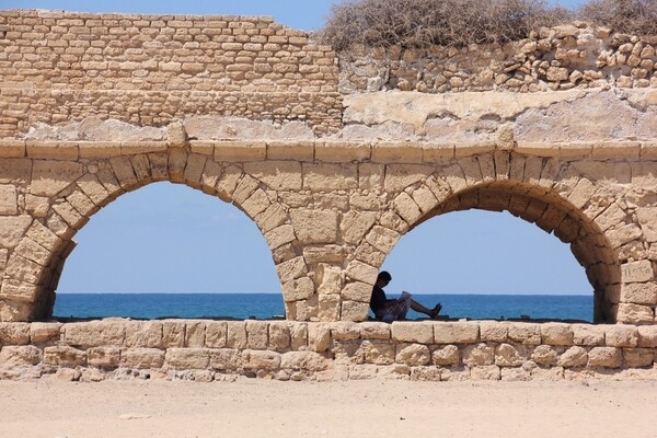 Present-day Caesarea, Israel, is located midway between Tel Aviv and Haifa on the coastal plain of the Mediterranean Sea. Herod the Great built the city, then known as Caesarea Maritima, around 25-13 B.C. as a major port.  With no reliable source of fresh water, Herod commissioned a system of aqueducts (surviving section shown) to supply water from nearby Mount Carmel. The aqueducts delivered water for 1,200 years, until canals were built.