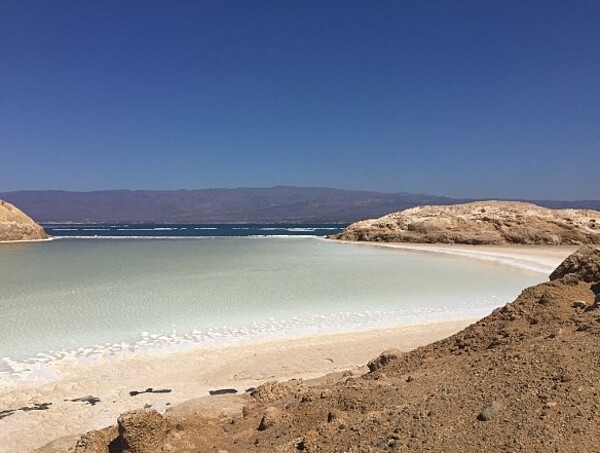 Lake Assal is a crater lake at the top of the Great Rift Valley, some 120 km (75 mi) west of Djibouti city. A saline lake, it lies 155 m (508 ft) below sea level in the Afar Triangle. It is the lowest depression on the African continent and one the world's largest salt reserves.