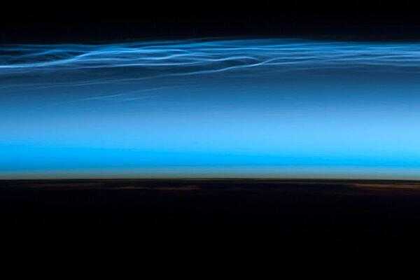 Polar mesospheric clouds - also known as noctilucent or &quot;night shining&quot; clouds - form between 76 to 85 km (47 to 53 mi) above the Earth&apos;s surface, near the boundary of the mesosphere and thermosphere, a region known as the mesopause. At these altitudes, water vapor can freeze into clouds of ice crystals. When the sun is below the horizon and the ground is in darkness, these high clouds may still be illuminated, lending them their ethereal, &quot;night shining&quot; qualities.

Polar mesospheric clouds have been observed from all human vantage points in both the Northern and Southern Hemispheres - from the surface, in aircraft, and from spacecraft - and tend to be most visible during the late spring and early summer. Image courtesy of NASA.