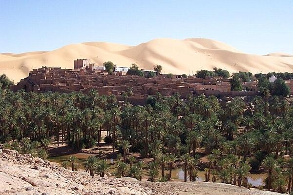 Mountains of sand loom over the oasis village of Taghit, Algeria, in the Sahara.