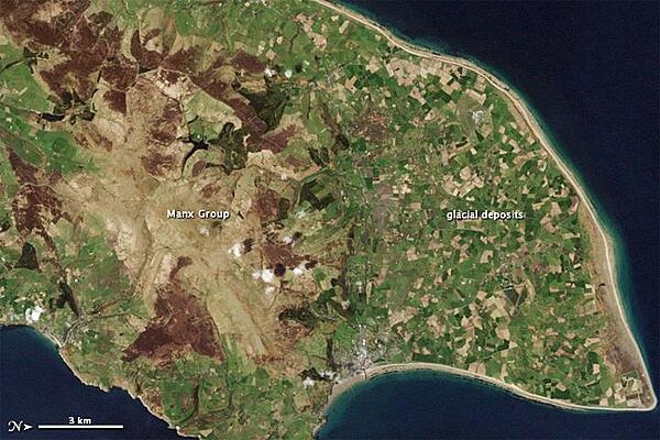 This natural-color satellite image of the Isle of Man from 1 May 2001 shows the northern end of the island; the image has been rotated so north is to the right. Croplands cover the relatively flat terrain of the northern coastal plain, which forms a rough triangle. Toward the south, the rock layers are collectively known as the Manx Group; they make up the bulk of the Isle of Man. Photo courtesy of NASA.