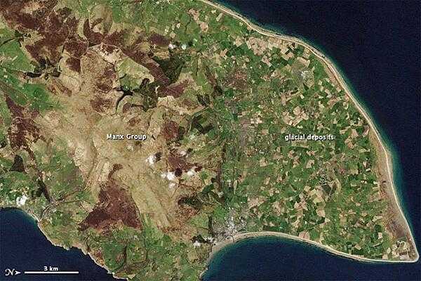 This natural-color satellite image of the Isle of Man from 1 May 2001 shows the northern end of the island; the image has been rotated so north is to the right. Croplands cover the relatively flat terrain of the northern coastal plain, which forms a rough triangle. Toward the south, the rock layers are collectively known as the Manx Group; they make up the bulk of the Isle of Man. Photo courtesy of NASA.