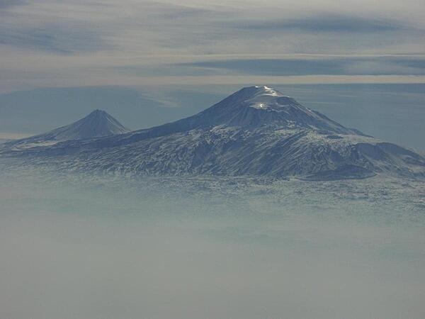 A view of Mount Ararat in western Turkey through the fog. The highest of its two peaks, Greater Ararat, is the tallest mountain in Turkey at 5,166 m (16,949 ft). Although located some 32 km (20 mi) from the Armenian border, the dormant volcano dominates the skyline of Yerevan, Armenia&apos;s capital. This photo was snapped after take-off from the Yerevan airport.