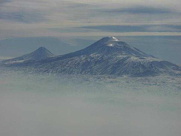 A view of Mount Ararat in western Turkey through the fog. The highest of its two peaks, Greater Ararat, is the tallest mountain in Turkey at 5,166 m (16,949 ft). Although located some 32 km (20 mi) from the Armenian border, the dormant volcano dominates the skyline of Yerevan, Armenia&apos;s capital. This photo was snapped after take-off from the Yerevan airport.