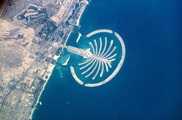 The artificial peninsula and islands that make up Palm Jumeirah in Dubai, as seen from the International Space Station. This massive earthwork is reclaimed from Dubai's Persian Gulf coast. Advertised as "being visible from the Moon," the palm-shaped structure displays 17 huge fronds framed by an 11-km (7 mi) protective barrier. Image courtesy of NASA.