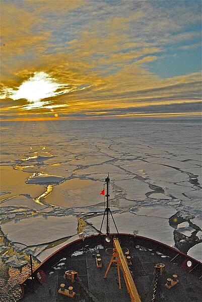 The early morning sun bursts through clouds over the Arctic Ocean in this view taken from atop the bridge of the USCGC Healy. Photo courtesy of the US Geologic Survey/ Jonathan Wynn.