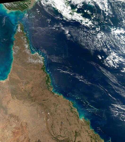 This view of the Queensland coast of northeast Australia, taken by the Aqua satellite, vividly shows the many offshore reefs that form the Great Barrier Reef. The white specks in the deeper blue waters of the Coral Sea to the east are some of the reefs, cays, and islets that make up the Coral Sea Islands. Image courtesy of NASA.